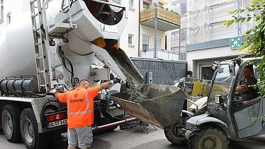 Foto von einem Betonmischer und Radlader vor einer Tiefagarage