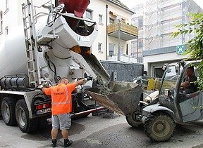 Foto von einem Betonmischer und Radlader vor einer Tiefagarage