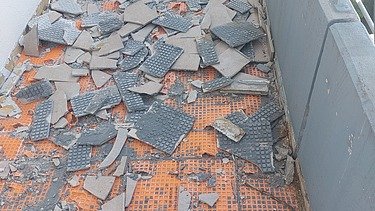 Foto von einem Balkon auf dem der Bodenbelag mit Abbruchhammer entfernt wird
