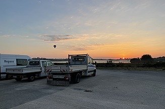 Instandsetzungen mit der Repass Sanierungstechnik Transporter und Sprinter mit Repass Aufdruck vor einem Sonnenuntergang mit Heißluftballon