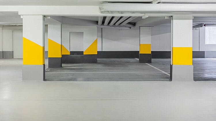 Foto von einer Tiefgarage mit Stützen in einer gelb-grauen Beschichtung