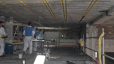 Foto von Mitarbeitern die Lamellen an die Decke anbringen