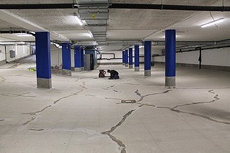 Abdichtungsarbeiten am Fußboden Foto von abgedichteten Rissen am Boden und einer Personen