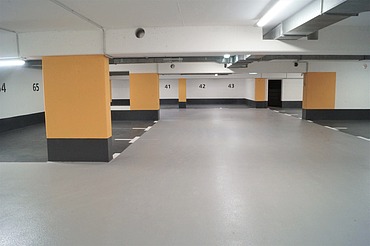 Instandgesetzte Tiefgarage mit Oberflächenschutz Foto einer Tiefgarage mit schwarz-gelben Farbakzenten