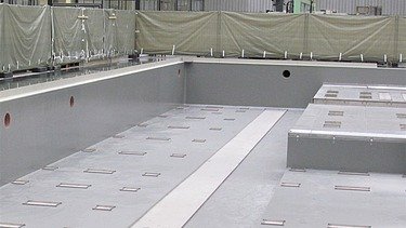 Foto einer Halle mit einem Becken und Absperrungen im Hintergrund