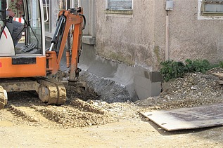 Foto von einem Bagger vor einer Hauswand