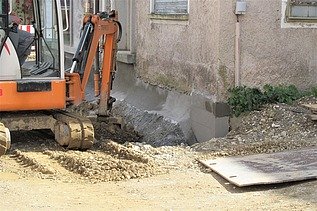 Foto von einem Bagger vor einer Hauswand