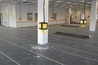 Foto von einer Halle mit herunterhängenden Stromanschlüssen