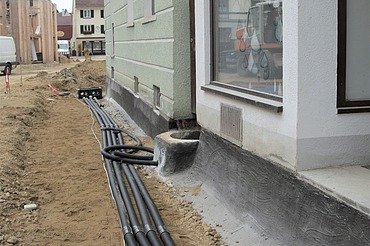Drainage Foto von schwarzen Drainagerohren vor einem Fundament