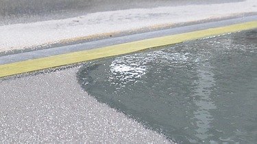 Nahaufnahmen einer schimmernden Flüssigkeit auf dem Boden