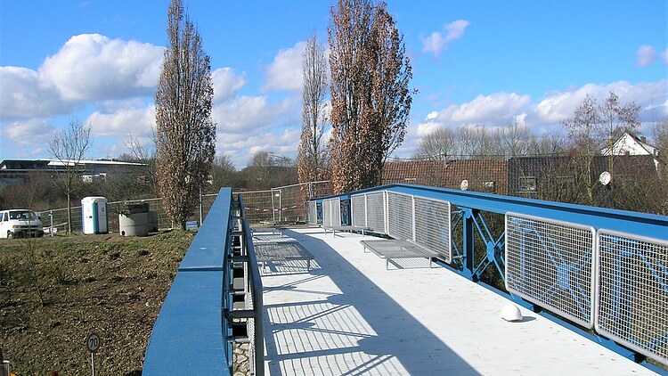Foto von einer Stahlbrücke mit Landschaft im Hintergrund