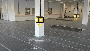 Foto von einer Halle mit herunterhängenden Stromanschlüssen