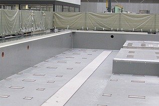 Foto einer Halle mit einem Becken und Absperrungen im Hintergrund